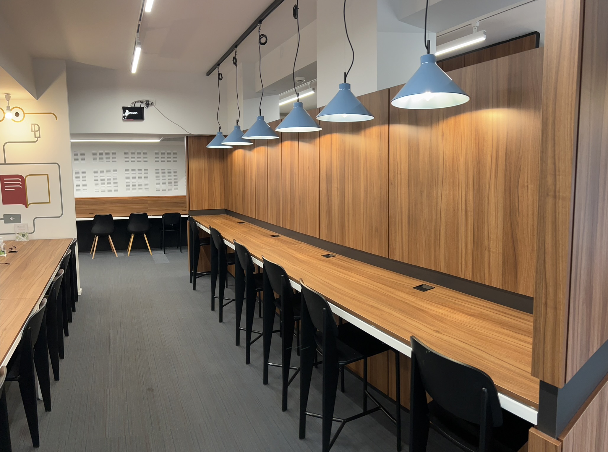 Ο χώρος μελέτης του Canteen Spirit με ξύλινους πάγκους, ατομικές θέσεις και φωτιστικά